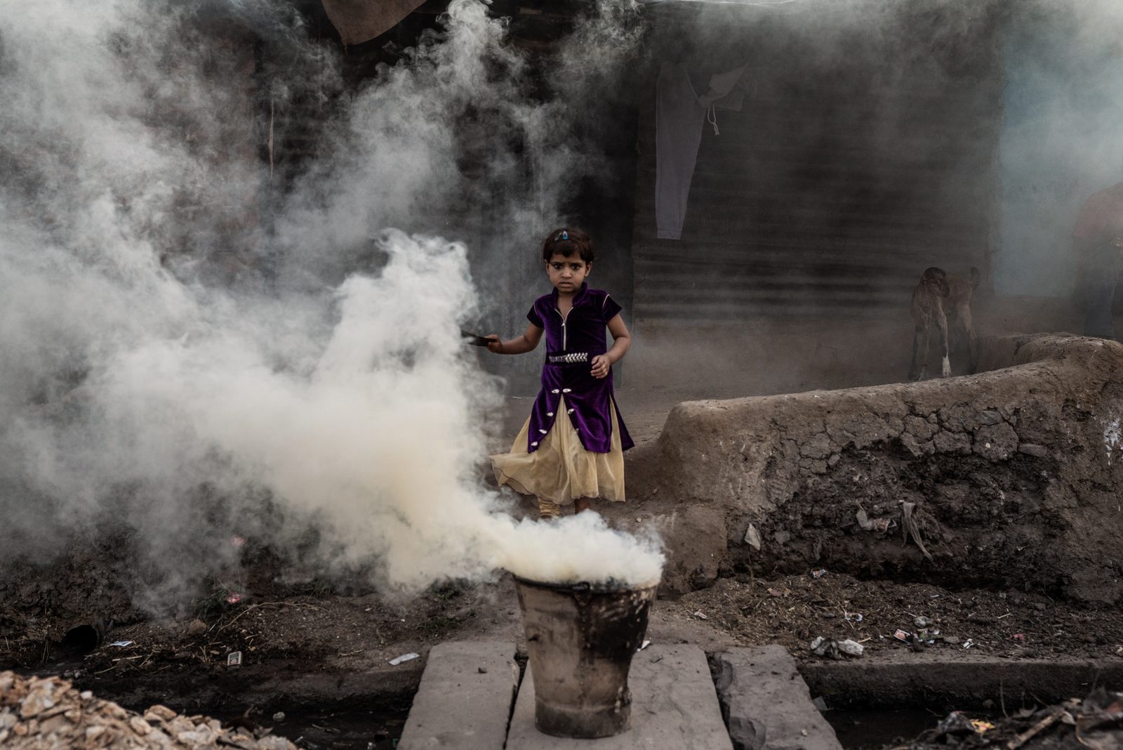 A young girl emerges from the smoke coming from her family's chula in Madhya Pradesh India