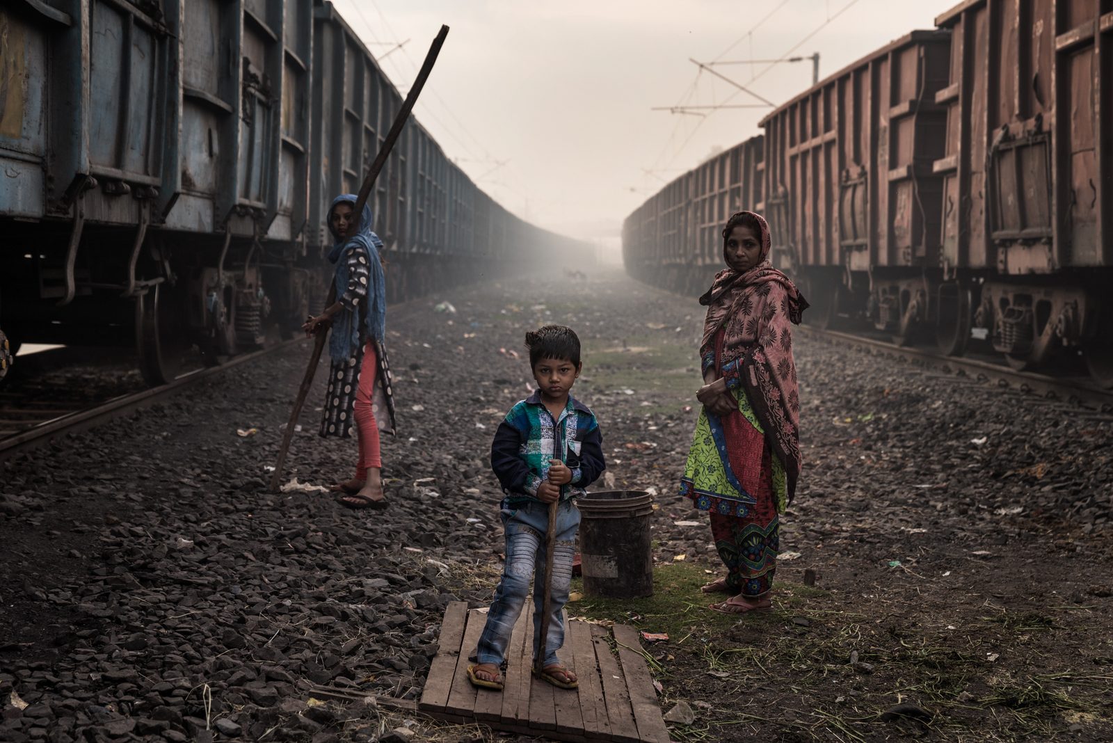 A family waits to the trains to stop before breaking into the carraiges to scavenge for leftover coal
