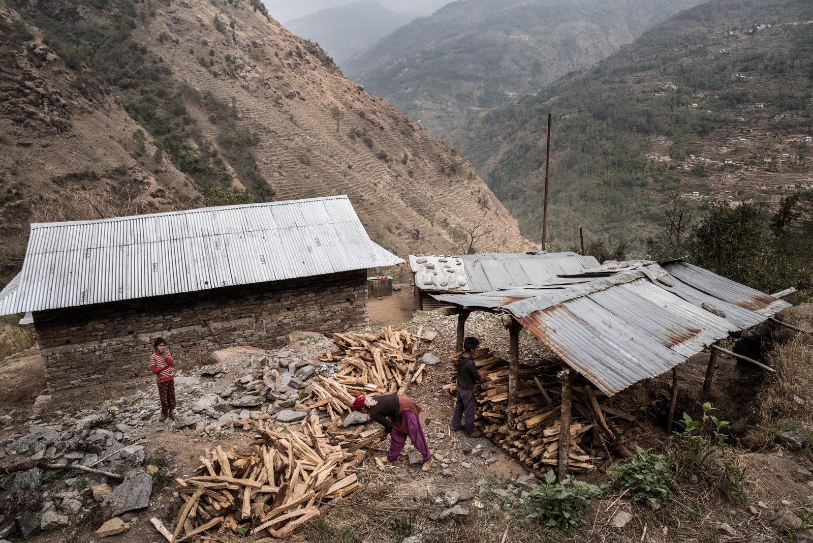 A mother and her two children prepare firewood in the lower Himalayas of Nepal
