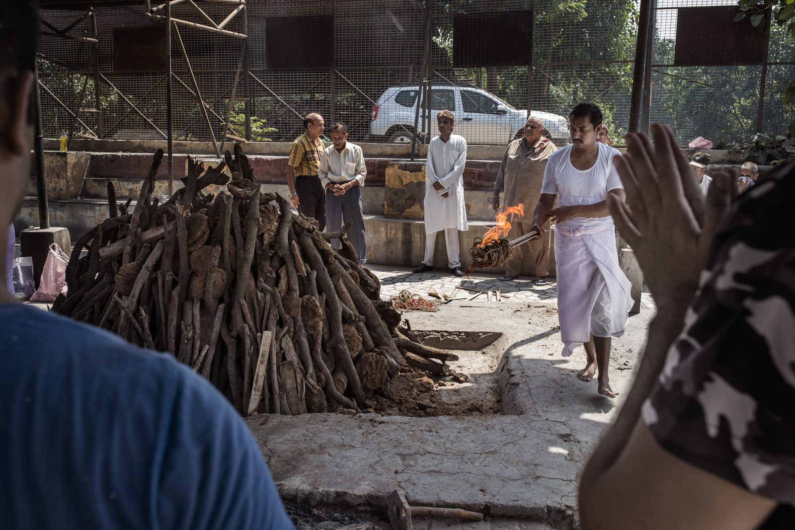 A body covered in wood and dried cow dung is ready for cremation in Uttar Pradesh, India