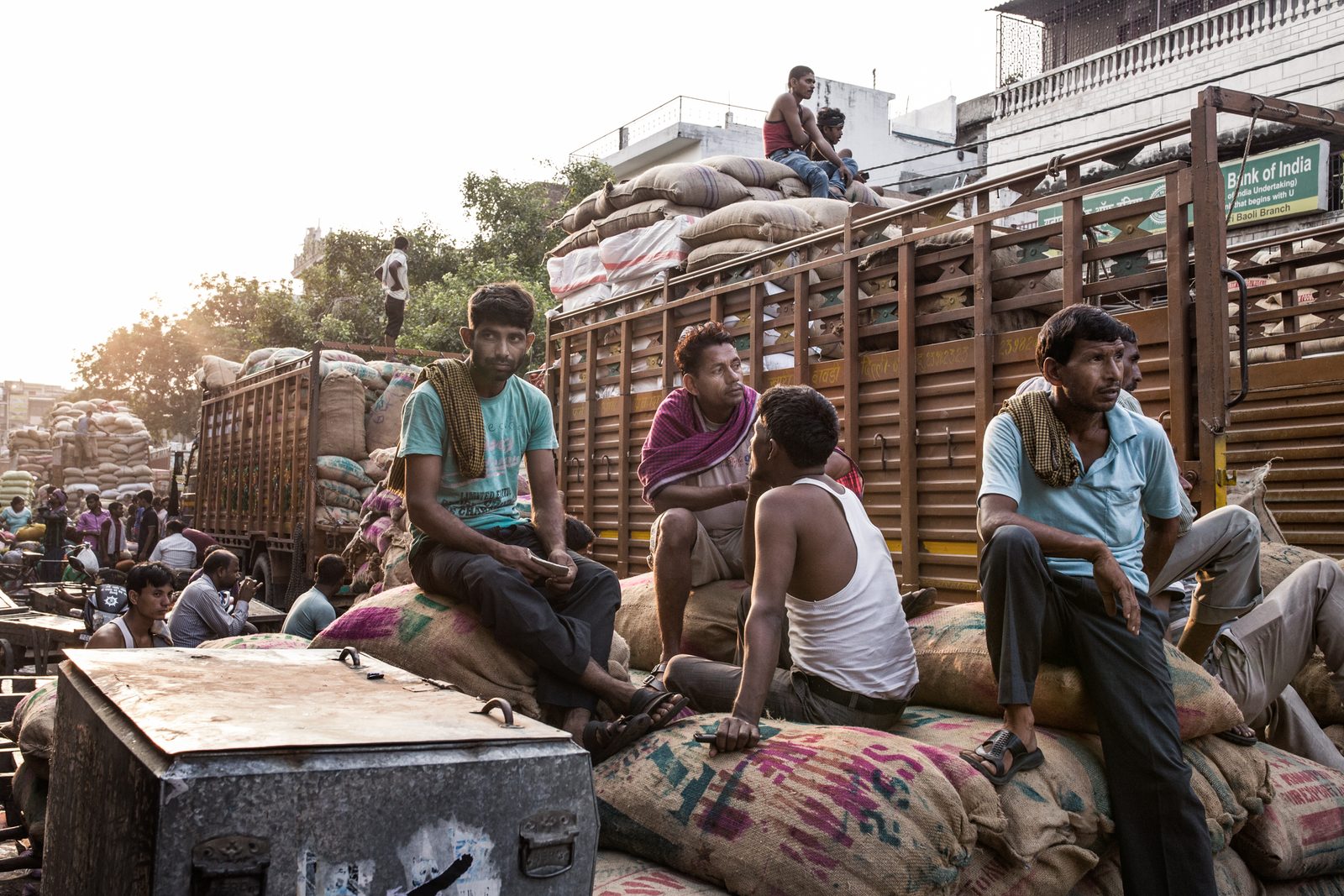 Labourers take a break after carrying goods off diesel-fuelled trucks in New Delhi, India.