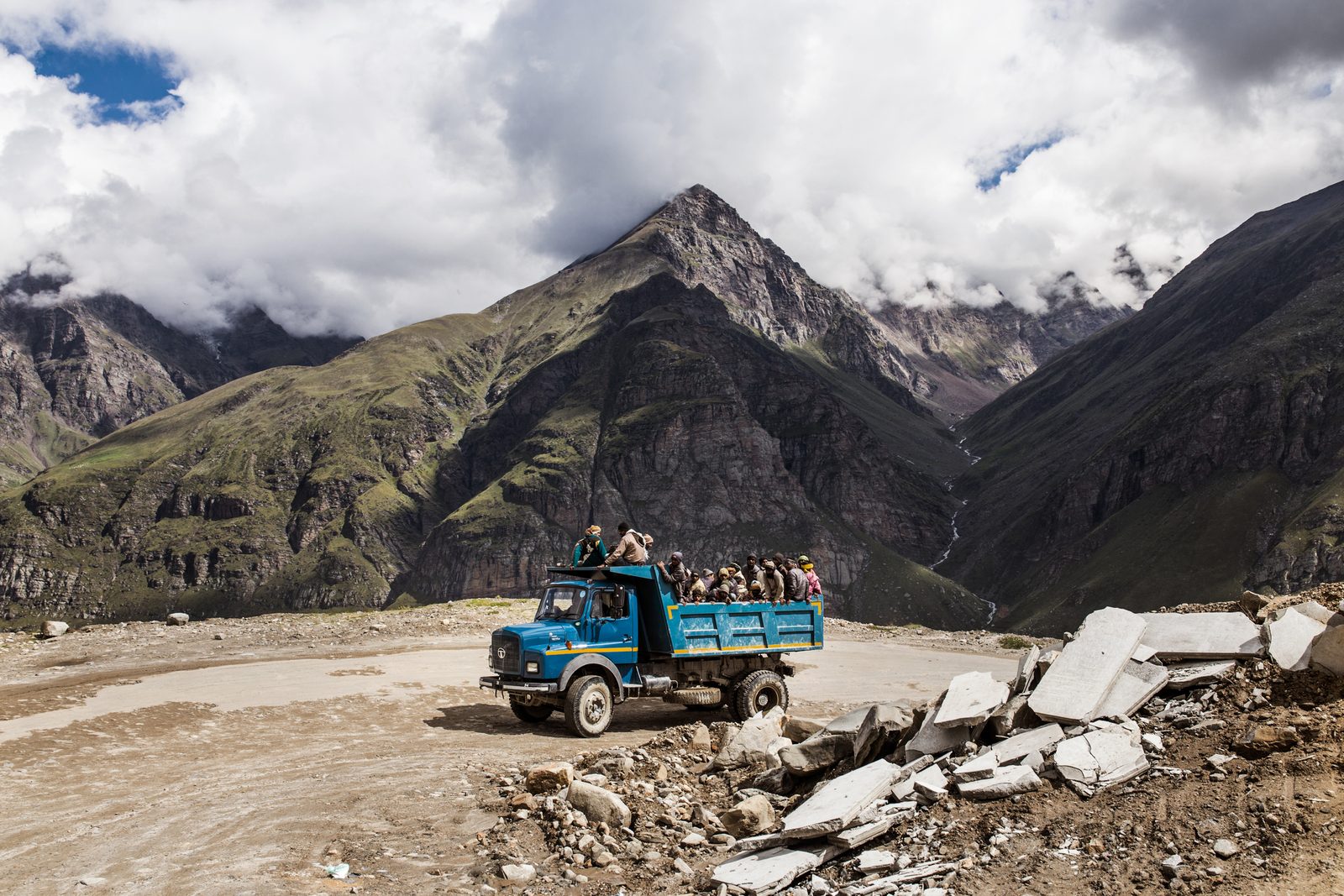 Migrant labourers from India's lower regions heading towards another site on a diesel-fuelled truck on newly built Himalayan roads.