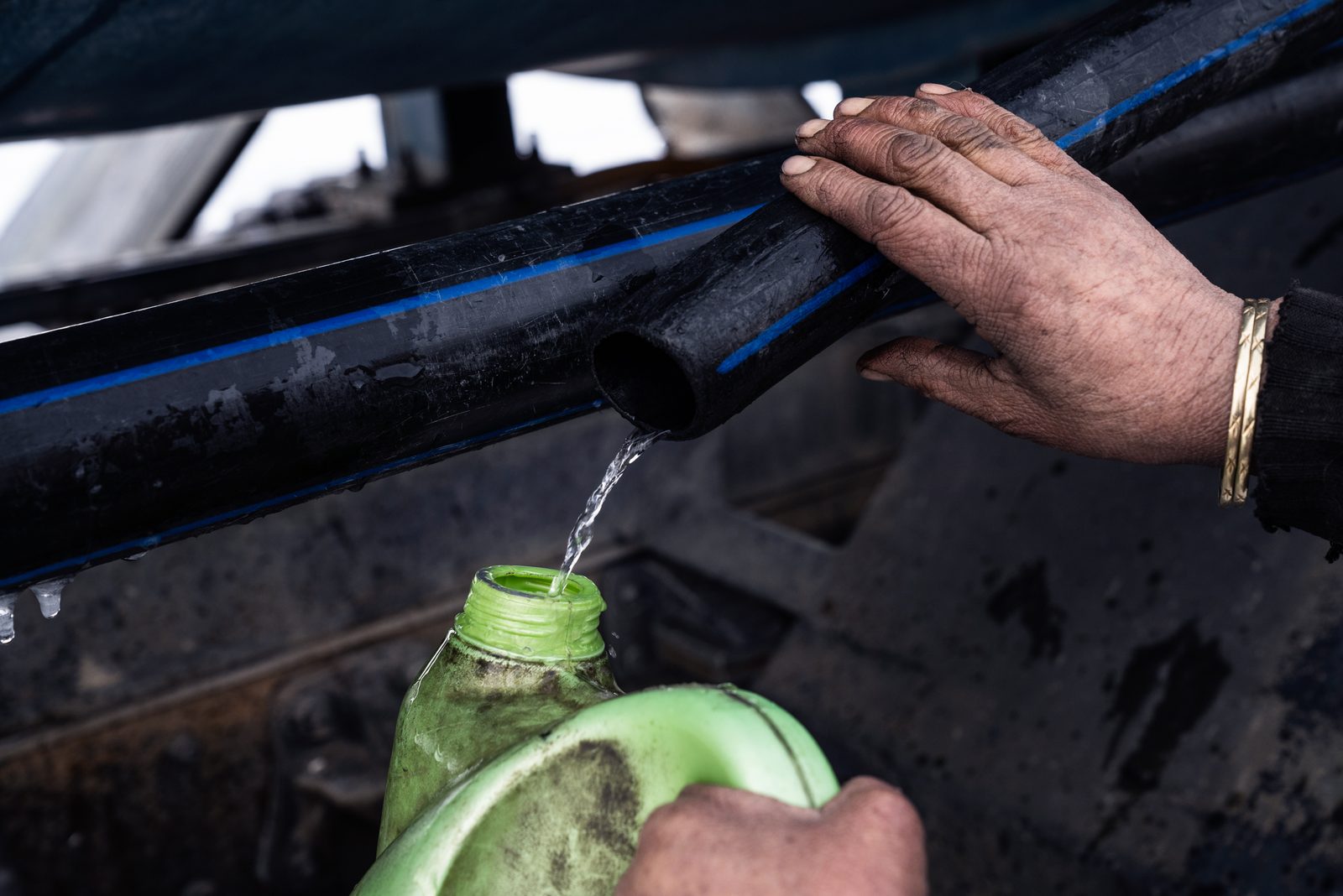 A woman collects water from the government water tanker delivering emergency supplies to Kumik