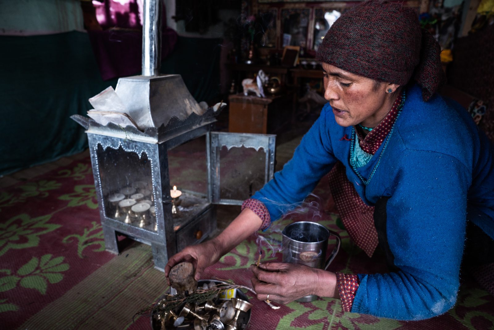 Tsewang Zangmo lights incense for her morning prayer ritual