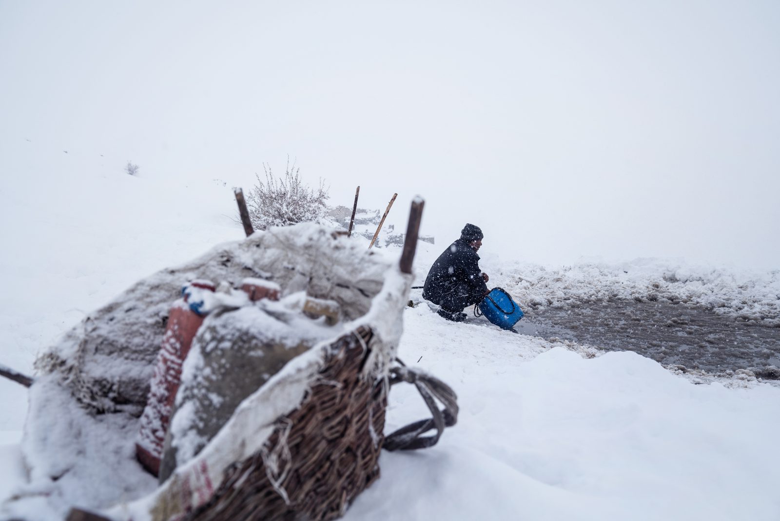 A villager of Kumik collects the last drops of water before a blizzard worsens