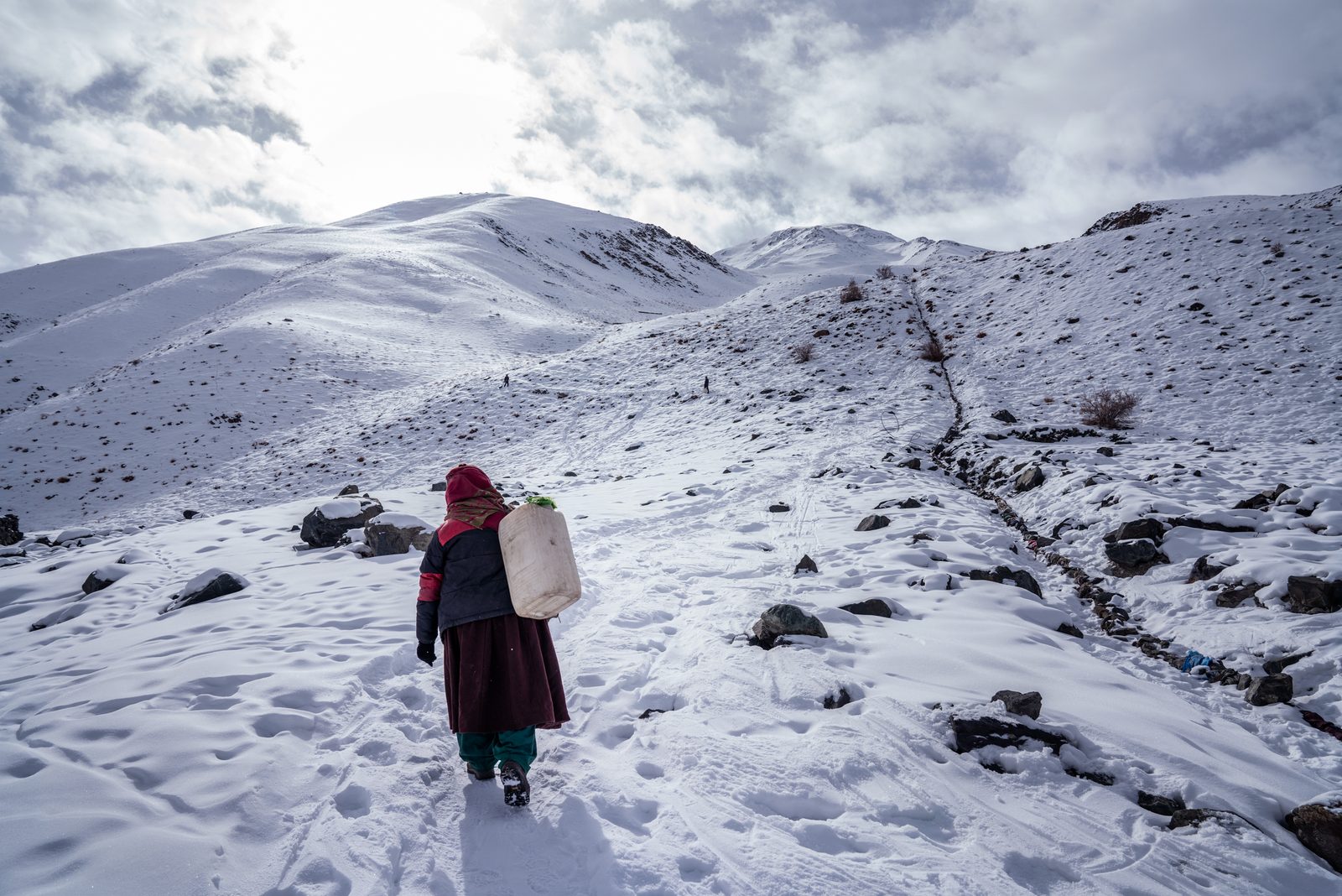 A villager of Kumik begins the long walk up to the water well