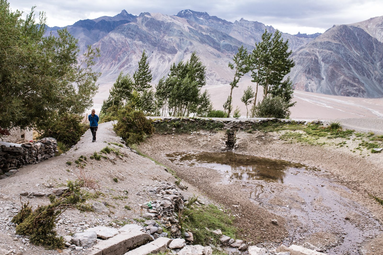 A villager of Kumik walks around an empty water storage dam