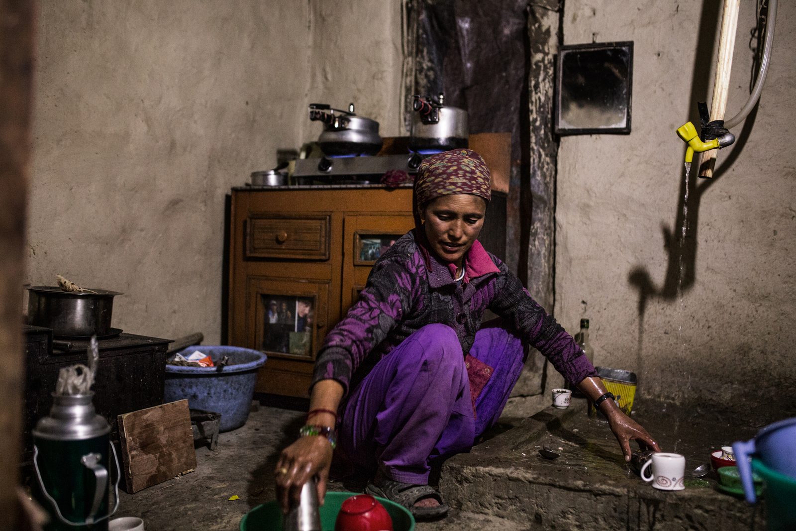 Tsewang Zangmo washes dishes inside her summer kitchen