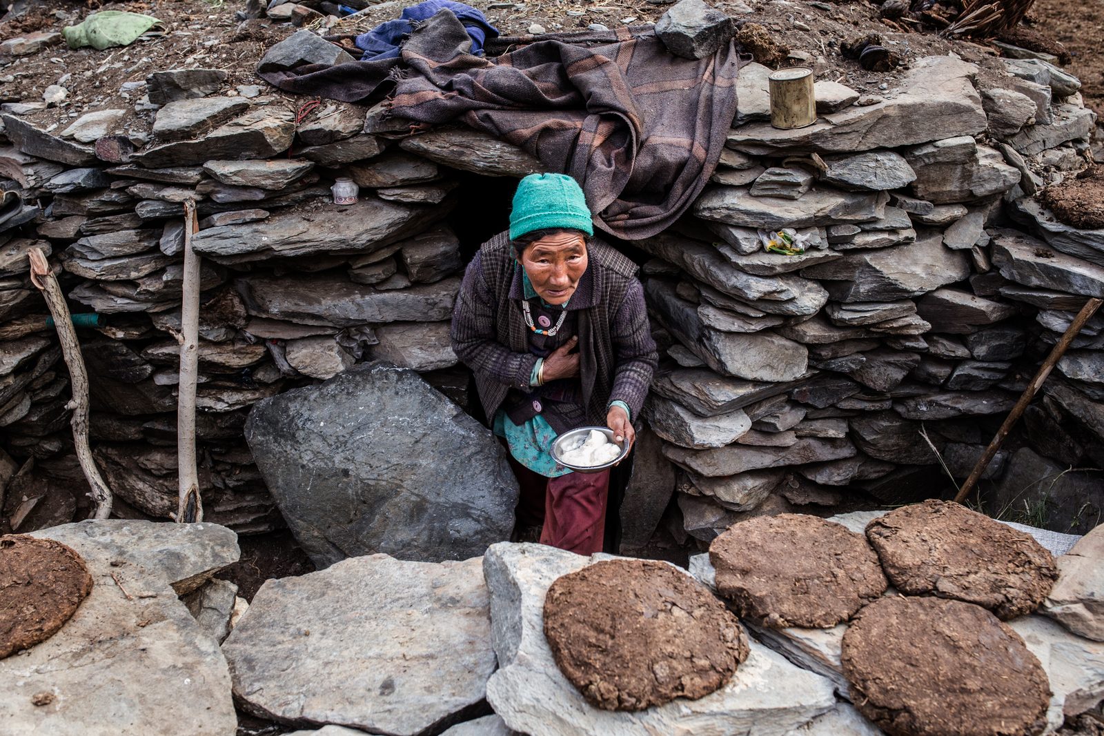 Sonam Yangdon serves fresh curd as she emerges from an outdoor shelter