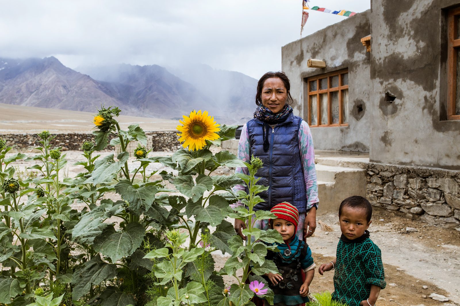 Tenzin Chezin and her children stand outside their new home in Lower Kumik - the new village separate from Kumik.