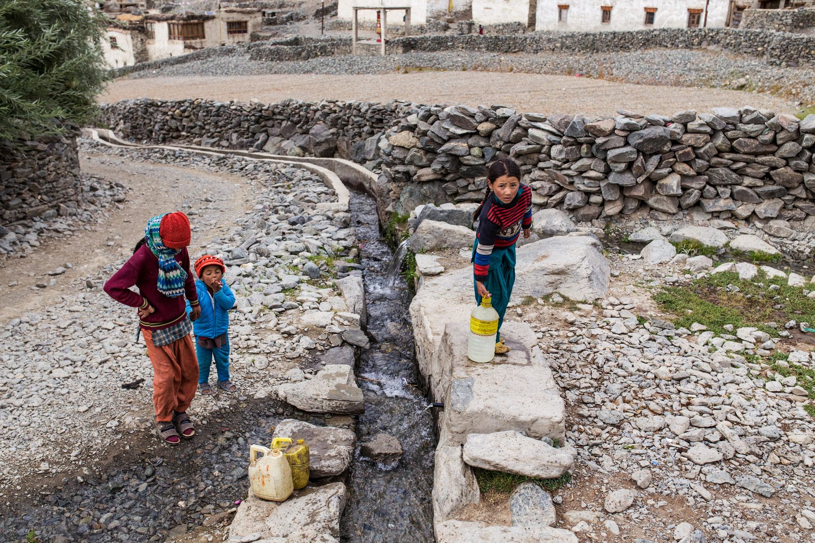 Children of Kumik collect water from the canal that runs through the village during summer